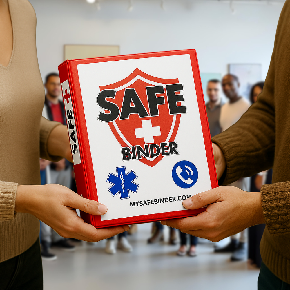 Two people holding a SAFE Binder with a group of people in the background