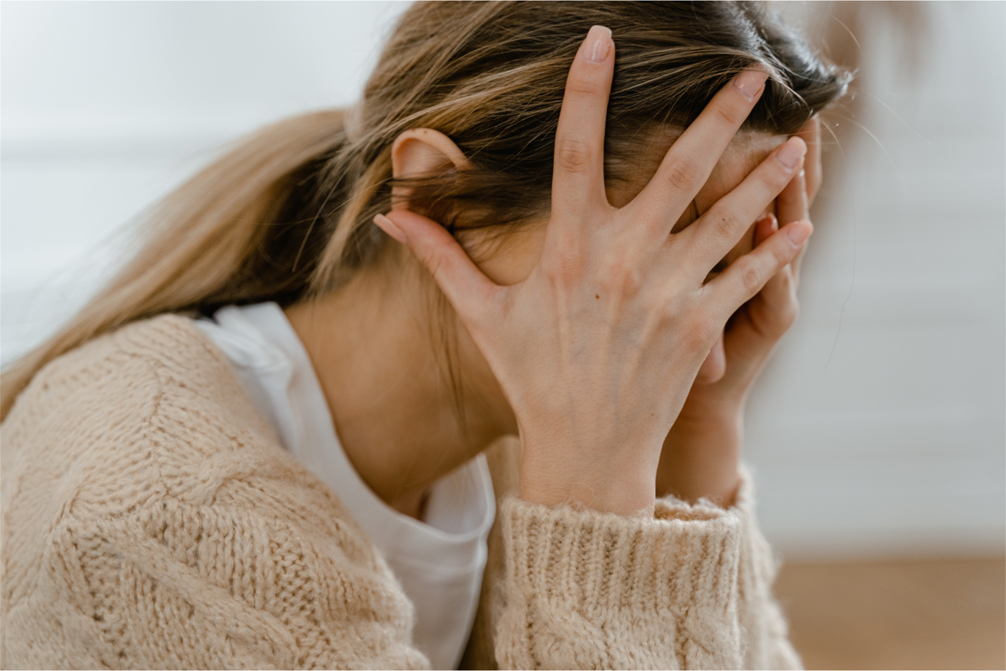 A frustrated woman covering her face with her hands
