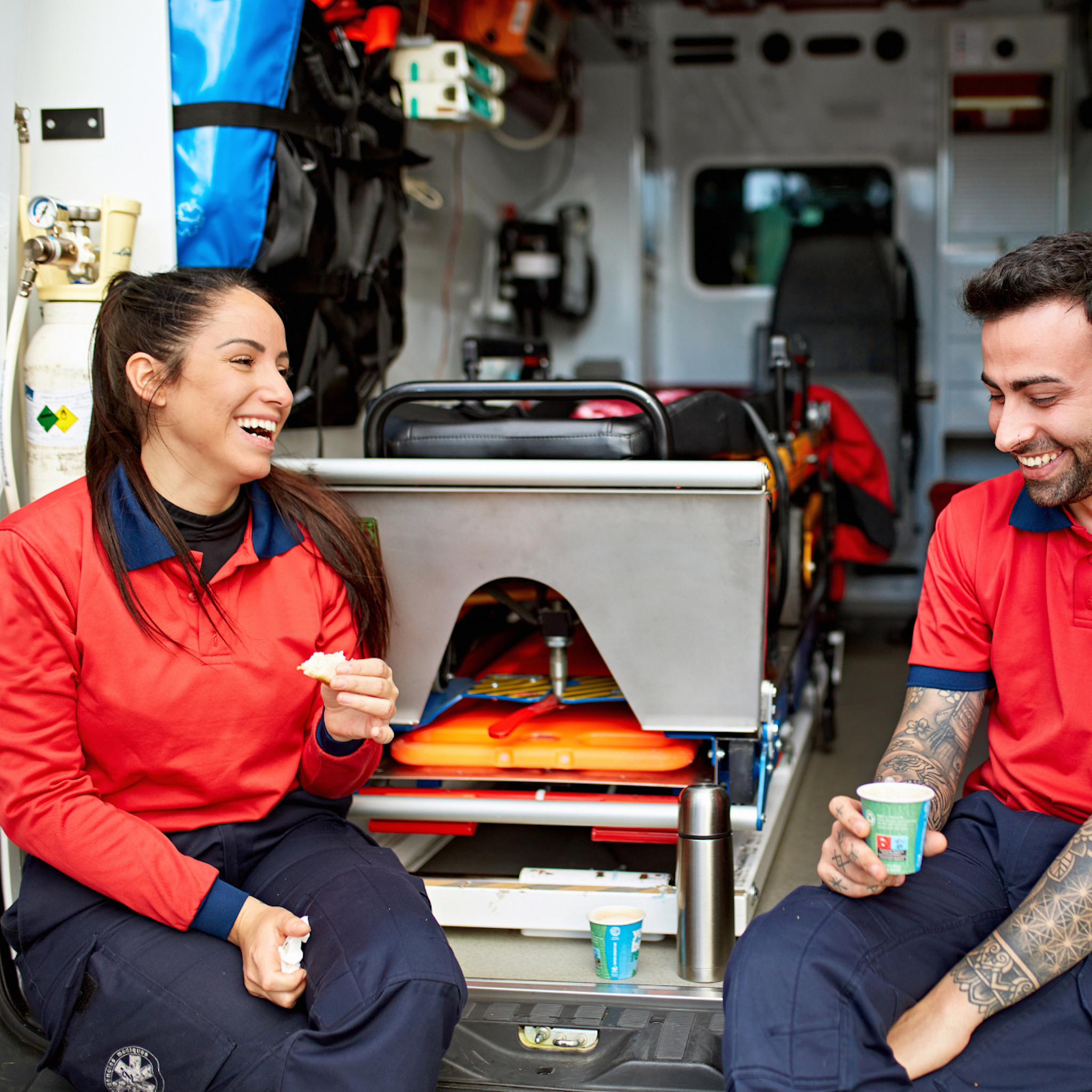 First responders sitting on the back of their rig drinking coffee and eating