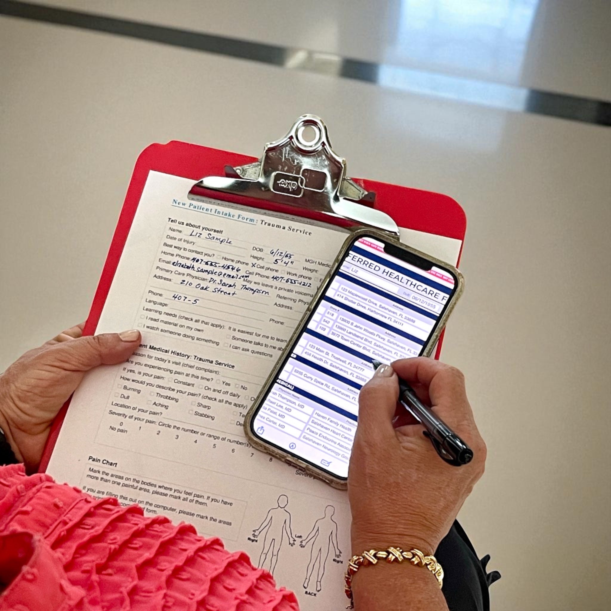 Person holding a clipboard with a form and a phone displaying a digital form