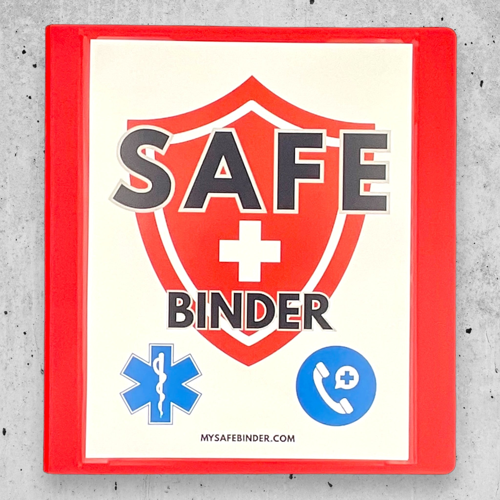 Red SAFE Binder with medical symbols on a gray concrete surface