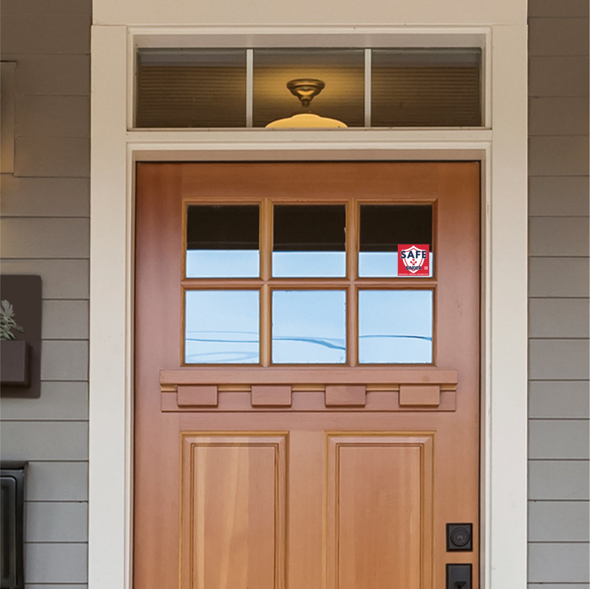 Wooden front door with glass panels and a window cling on a house exterior.